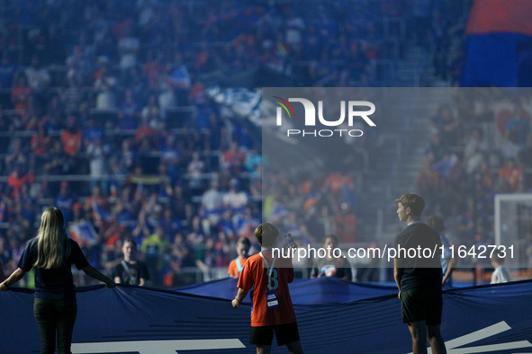 A boy records on his cell phone while holding the MLS banner before the start of the Major League Soccer match between FC Cincinnati and Orl...