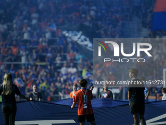 A boy records on his cell phone while holding the MLS banner before the start of the Major League Soccer match between FC Cincinnati and Orl...