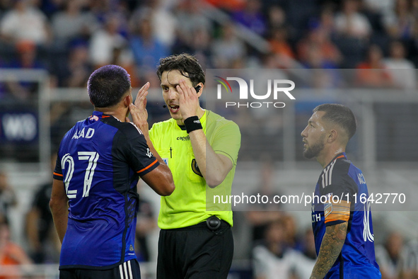 Referee Filip Dujic explains a call to Cincinnati midfielder Yamil Asad during the Major League Soccer match between FC Cincinnati and Orlan...