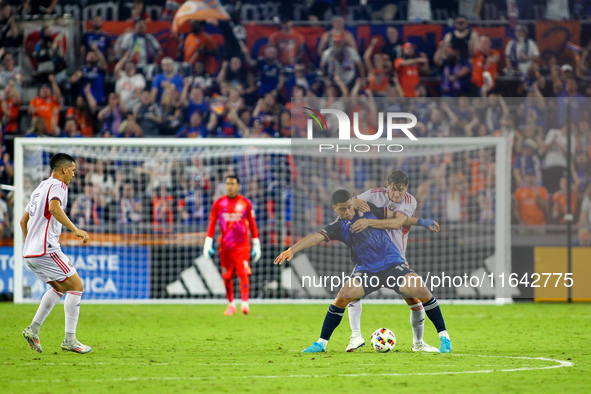 Cincinnati attacker Kevin Kelsy and Orlando defender Rodrigo Schlegel compete for the ball during the Major League Soccer match between FC C...