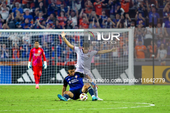 Cincinnati attacker Kevin Kelsy and Orlando defender Rodrigo Schlegel compete for the ball during the Major League Soccer match between FC C...