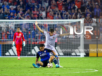 Cincinnati attacker Kevin Kelsy and Orlando defender Rodrigo Schlegel compete for the ball during the Major League Soccer match between FC C...