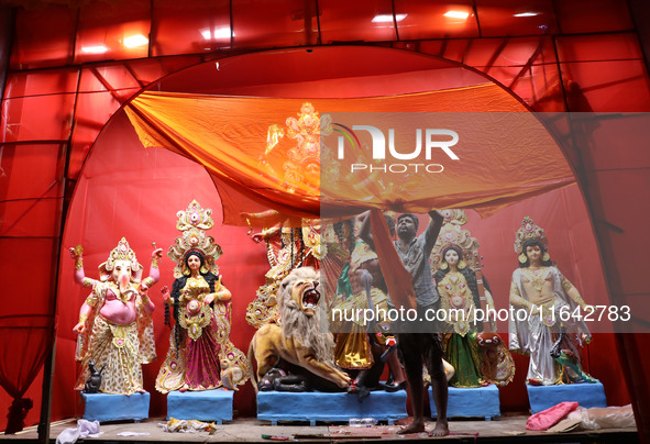 A worker works in a ''pandal'' or temporary platform in front of idols of the Hindu goddess Durga ahead of the Durga Puja festival in Kolkat...