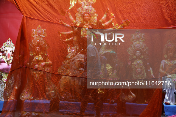 A worker works in a ''pandal'' or temporary platform in front of idols of the Hindu goddess Durga ahead of the Durga Puja festival in Kolkat...