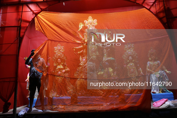 A worker works in a ''pandal'' or temporary platform in front of idols of the Hindu goddess Durga ahead of the Durga Puja festival in Kolkat...