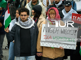 A woman holds a sign reading ''Never again! For all'' during a rally in support of Palestine and Gaza in Warsaw, Poland on 05 October, 2024....