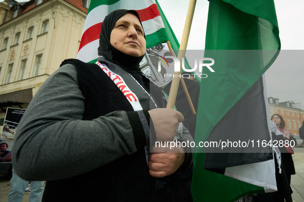 A woman holds a Palestinian flag during a rally in Warsaw, Poland on 05 October, 2024. About a hundred people marched from the Royal Castle...