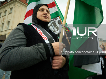 A woman holds a Palestinian flag during a rally in Warsaw, Poland on 05 October, 2024. About a hundred people marched from the Royal Castle...