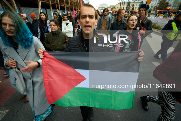 A man holds a Palestinian flag during a rally in Warsaw, Poland on 05 October, 2024. About a hundred people marched from the Royal Castle Sq...