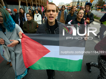 A man holds a Palestinian flag during a rally in Warsaw, Poland on 05 October, 2024. About a hundred people marched from the Royal Castle Sq...