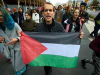 A man holds a Palestinian flag during a rally in Warsaw, Poland on 05 October, 2024. About a hundred people marched from the Royal Castle Sq...