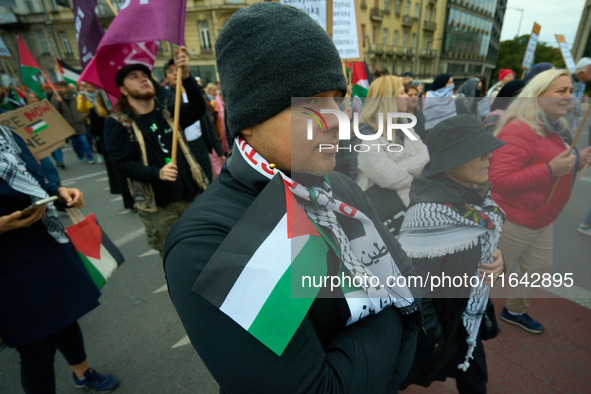 A man holds a Palestinian flag in Warsaw, Poland on 05 October, 2024. About a hundred people marched from the Royal Castle Square to the US...