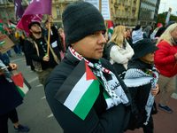 A man holds a Palestinian flag in Warsaw, Poland on 05 October, 2024. About a hundred people marched from the Royal Castle Square to the US...