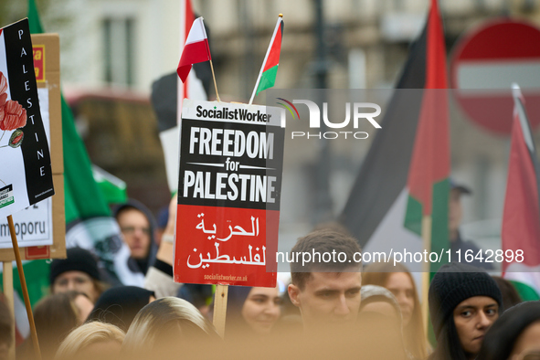 A protester holds a sign in Warsaw, Poland on 05 October, 2024. About a hundred people marched from the Royal Castle Square to the US embass...