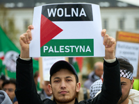 A man holds a sign reading ''Free Palestine'' in Warsaw, Poland on 05 October, 2024. About a hundred people marched from the Royal Castle Sq...