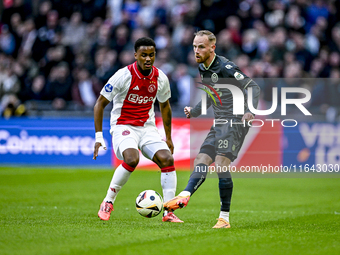 AFC Ajax Amsterdam defender Jorrel Hato and FC Groningen forward Romano Postema play during the match between Ajax and Groningen at the Joha...