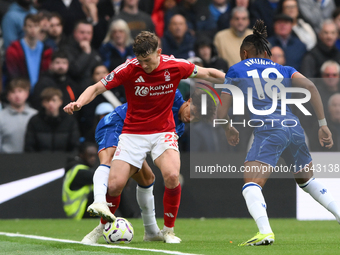 Ryan Yates of Nottingham Forest shields the ball from Joao Felix of Chelsea and Christopher Nkunku of Chelsea during the Premier League matc...