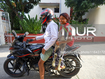 A Nepali customer carries a he-goat on the back of a motorcycle after selecting it at a subsidized outlet operated by the government in Kath...