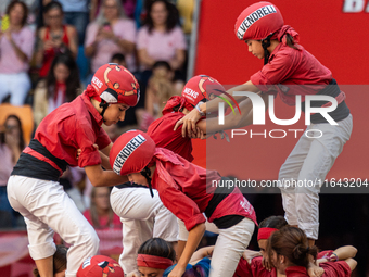 Children of Nens del Vendrell build the final part of the human tower during the Concurs de Castells competition in Tarragona, Spain, on Oct...