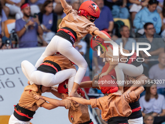 Children of Xiquets de Reus build the final part of the human tower during the Concurs de Castells competition in Tarragona, Spain, on Octob...