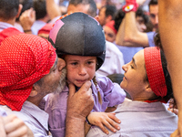 A little girl from Colla Jove Xiquets de Tarragona cries with happiness after successfully dismantling a human tower during the Concurs de C...