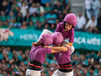 Children of Moixiganguers d'Igualada build the final part of the human tower during the Concurs de Castells competition in Tarragona, Spain,...