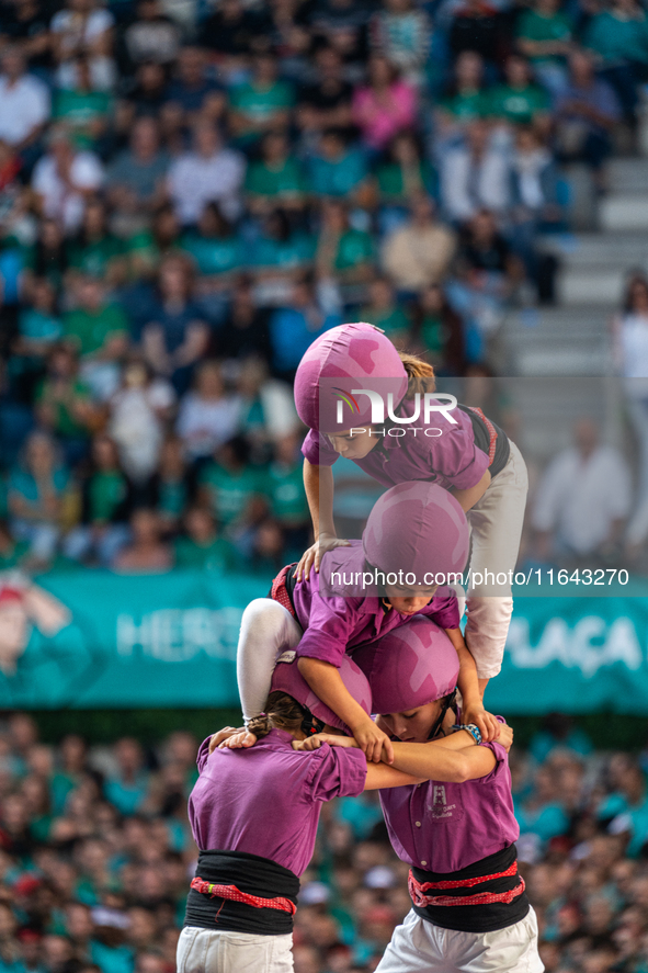 Children of Moixiganguers d'Igualada build the final part of the human tower during the Concurs de Castells competition in Tarragona, Spain,...