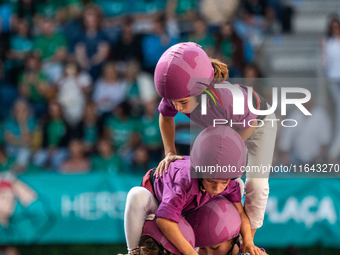 Children of Moixiganguers d'Igualada build the final part of the human tower during the Concurs de Castells competition in Tarragona, Spain,...