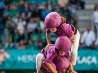 Children of Moixiganguers d'Igualada build the final part of the human tower during the Concurs de Castells competition in Tarragona, Spain,...