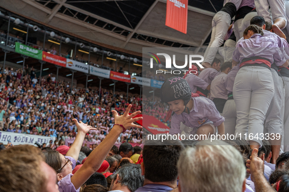 A mother holds her daughter in her arms after completing a human tower by Colla Jove Xiquets de Tarragona during the Concurs de Castells com...