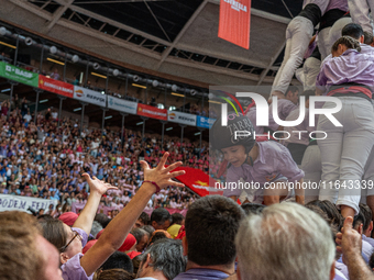 A mother holds her daughter in her arms after completing a human tower by Colla Jove Xiquets de Tarragona during the Concurs de Castells com...