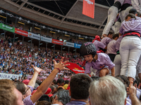 A mother holds her daughter in her arms after completing a human tower by Colla Jove Xiquets de Tarragona during the Concurs de Castells com...