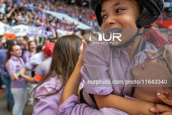 A mother holds her daughter in her arms after completing a human tower by Colla Jove Xiquets de Tarragona during the Concurs de Castells com...