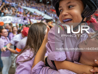 A mother holds her daughter in her arms after completing a human tower by Colla Jove Xiquets de Tarragona during the Concurs de Castells com...