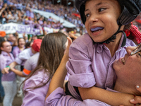 A mother holds her daughter in her arms after completing a human tower by Colla Jove Xiquets de Tarragona during the Concurs de Castells com...