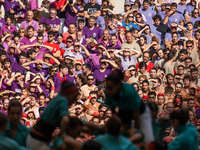 People watch members of the colla Castellers de Vilafranca build a human tower during the Concurs de Castells competition in Tarragona, Spai...