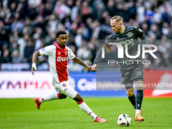 AFC Ajax Amsterdam defender Jorrel Hato and FC Groningen forward Romano Postema play during the match between Ajax and Groningen at the Joha...