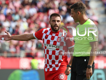 The referee Juan Luis Pulido Santana and David Lopez are present during the match between Girona FC and Athletic Club, corresponding to week...