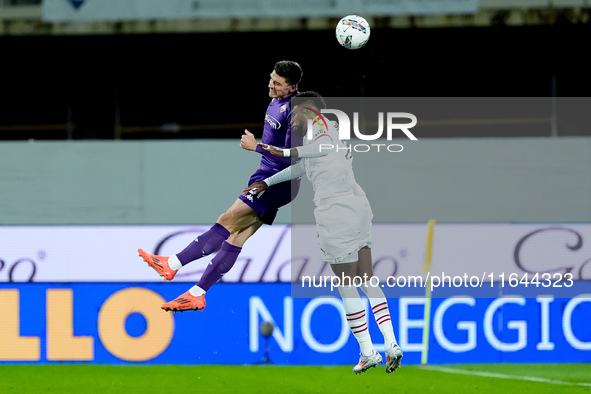 Emerson Royal of AC Milan and Moise Kean of ACF Fiorentina jump for the ball during the Serie A Enilive match between ACF Fiorentina and AC...