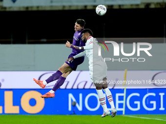 Emerson Royal of AC Milan and Moise Kean of ACF Fiorentina jump for the ball during the Serie A Enilive match between ACF Fiorentina and AC...