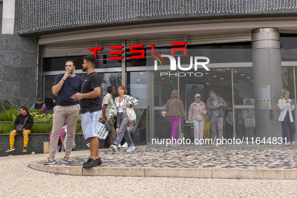 In Lisbon, Portugal, on October 6, 2024, people walk by a Tesla dealer. Tesla's third-quarter 2024 results show strong vehicle production, w...