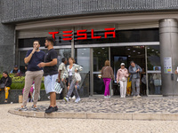 In Lisbon, Portugal, on October 6, 2024, people walk by a Tesla dealer. Tesla's third-quarter 2024 results show strong vehicle production, w...