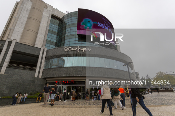 In Lisbon, Portugal, on October 6, 2024, people walk by a Tesla dealer. Tesla's third-quarter 2024 results show strong vehicle production, w...