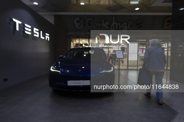 A person walks by a Tesla Model 3 car in Lisbon, Portugal, on October 6, 2024. Tesla's third-quarter 2024 results show strong vehicle produc...