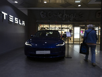 A person walks by a Tesla Model 3 car in Lisbon, Portugal, on October 6, 2024. Tesla's third-quarter 2024 results show strong vehicle produc...