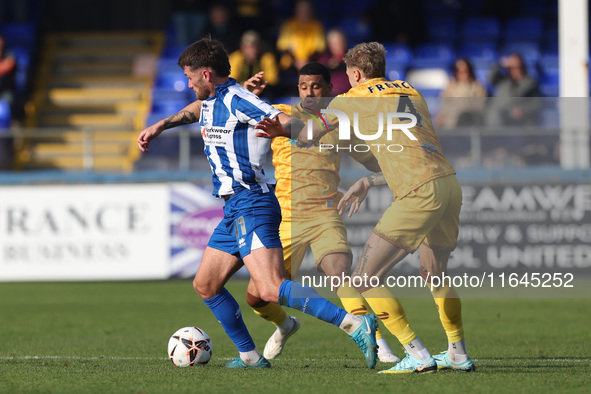 Luke Charman of Hartlepool United battles with Tyler French and Josh Coley of Sutton United during the Vanarama National League match betwee...