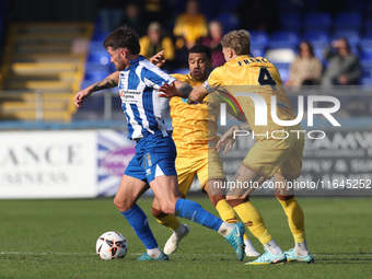 Luke Charman of Hartlepool United battles with Tyler French and Josh Coley of Sutton United during the Vanarama National League match betwee...