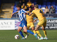 Luke Charman of Hartlepool United battles with Tyler French and Josh Coley of Sutton United during the Vanarama National League match betwee...