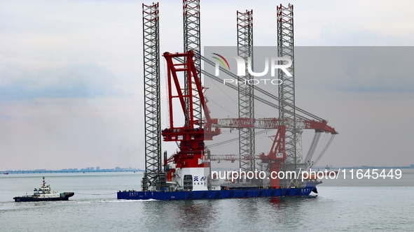 A high-horsepower tugboat pulls the fourth-generation offshore wind power construction platform ''Ganghangping 5'' off the Haixi Heavy Machi...