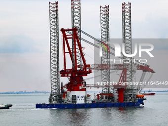 A high-horsepower tugboat pulls the fourth-generation offshore wind power construction platform ''Ganghangping 5'' off the Haixi Heavy Machi...